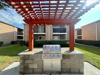 Outdoor grilling area with stainless steel barbecue and pergola
